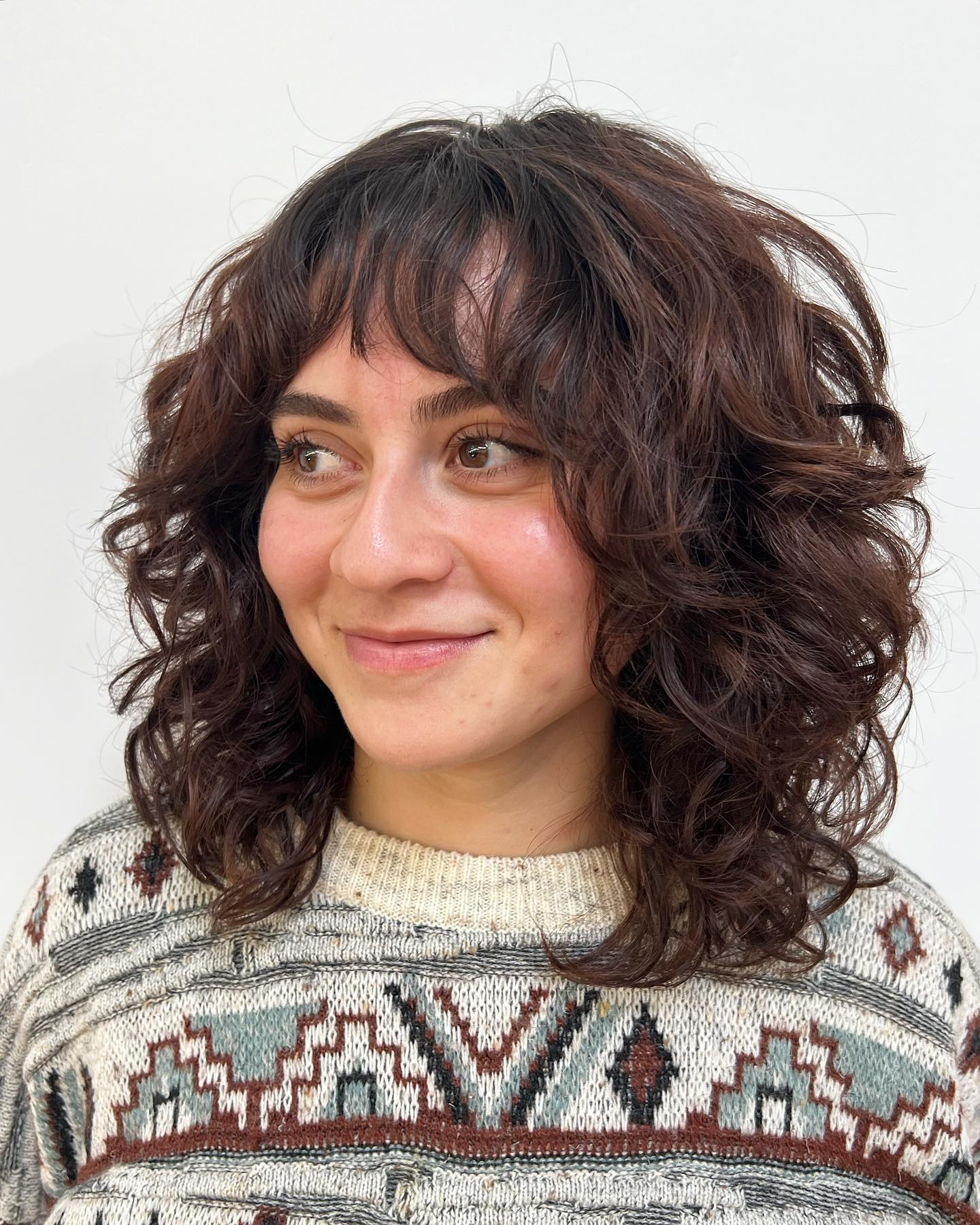 Mid Length Curly Shag with Arched Bangs